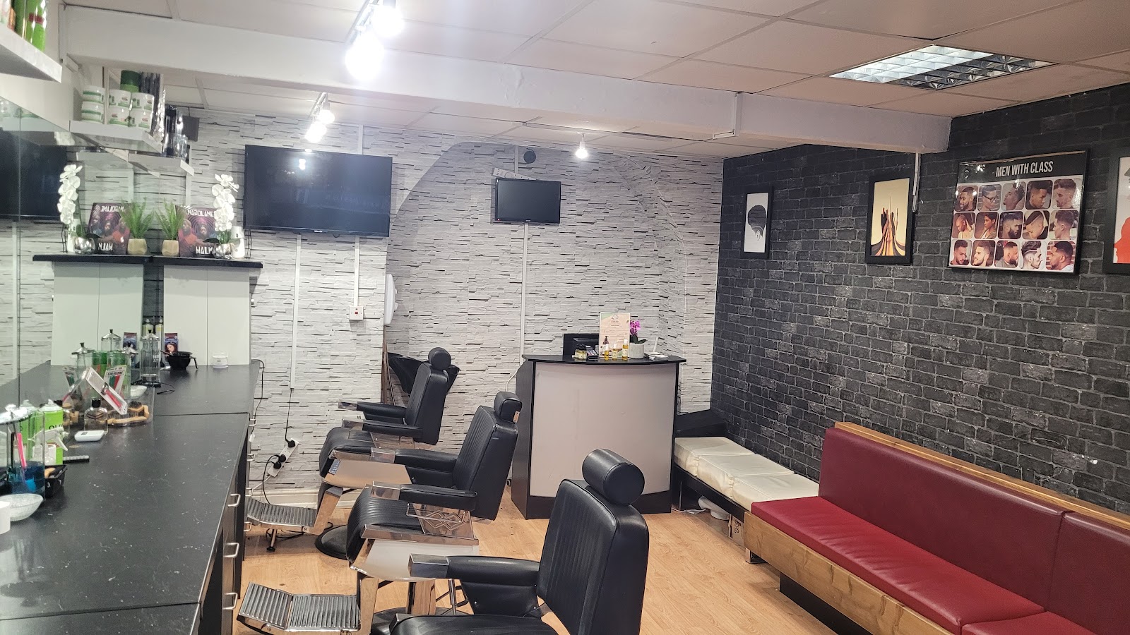 Interior of Modern Man in Limerick: black barber chairs, red waiting bench and brick-effect walls